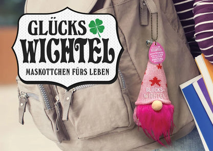 Rosa Glückswichtel am Rucksack befestigt, dazu das Logo mit dem Schriftzug ‚Glückswichtel – Maskottchen fürs Leben‘