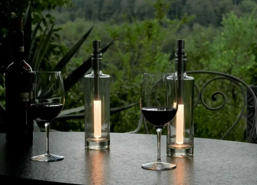 Bottlelight LED Flaschenlampe - 15 lm warmweiß / weiß - Moodbild mit einem Gartentisch, Wiengläsern und grünen Pflanzen im Hintergrund