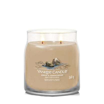 Yankee Candle Duftkerze - Amber & Sandalwood, Medium Glas mit brennenden Dochten