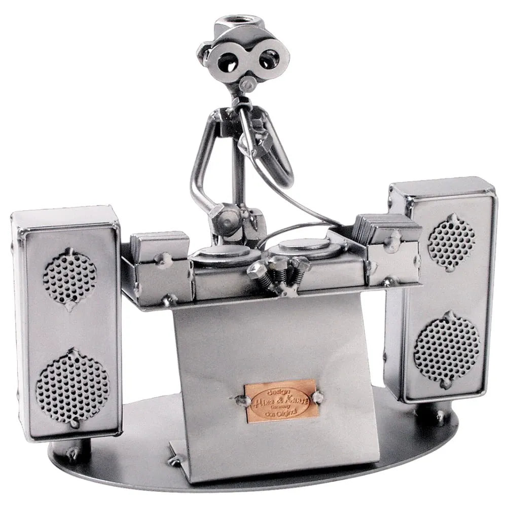 Schraubenfigur eines DJs mit Mikrofon hinter zwei Plattenspielern, flankiert von zwei großen Lautsprechern