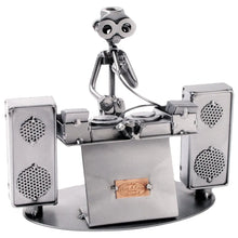 Schraubenfigur eines DJs mit Mikrofon hinter zwei Plattenspielern, flankiert von zwei großen Lautsprechern