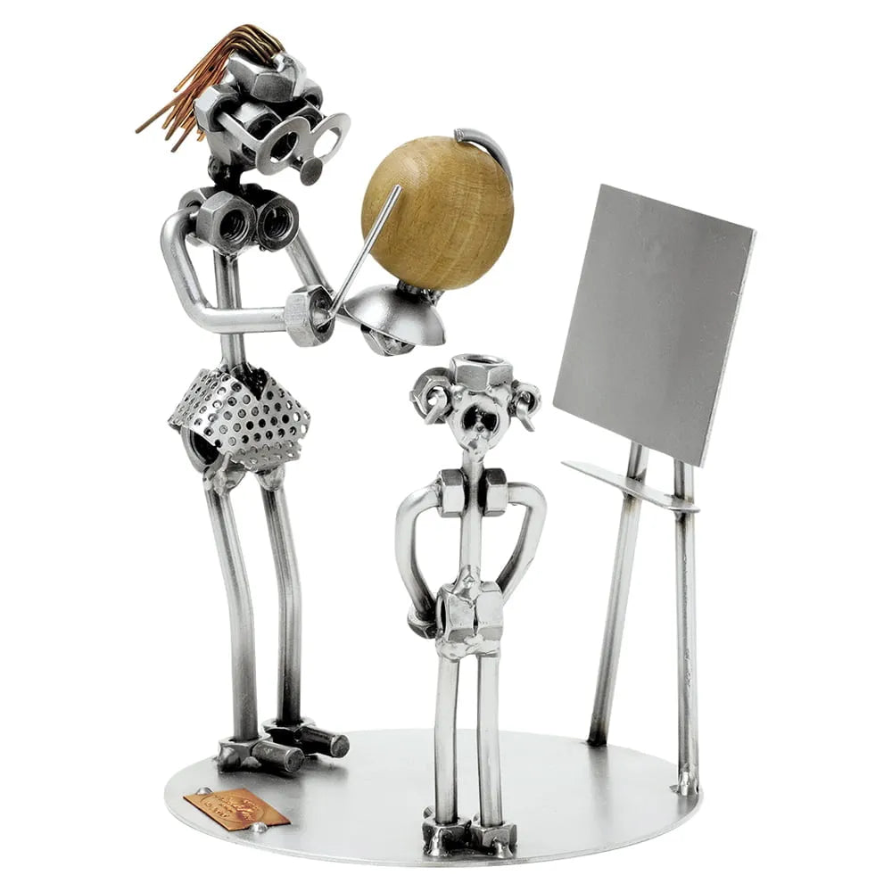 Schraubenfiguren aus Metall als Lehrerin mit Globus und Zeigestab neben einem Schüler und einer Tafel