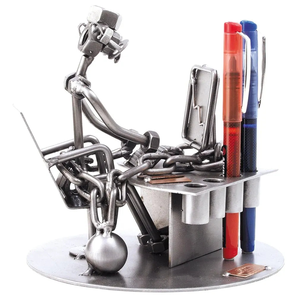 Schraubenfigur „Workaholic“ aus Metall am Computerschreibtisch mit Kette, Kugel und integriertem Stiftehalter