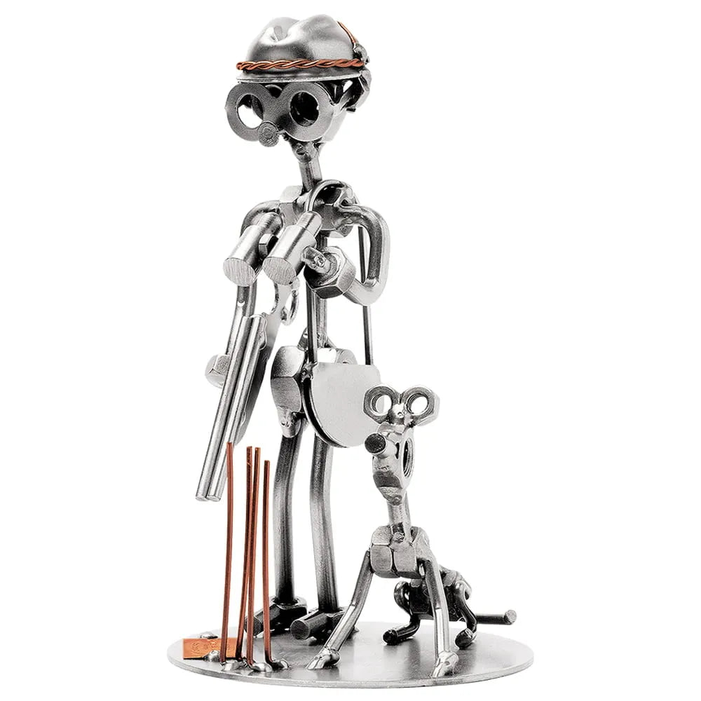 Schraubenfigur aus Metall als Jäger mit Hut, Fernglas und Gewehr neben einem sitzenden Jagdhund