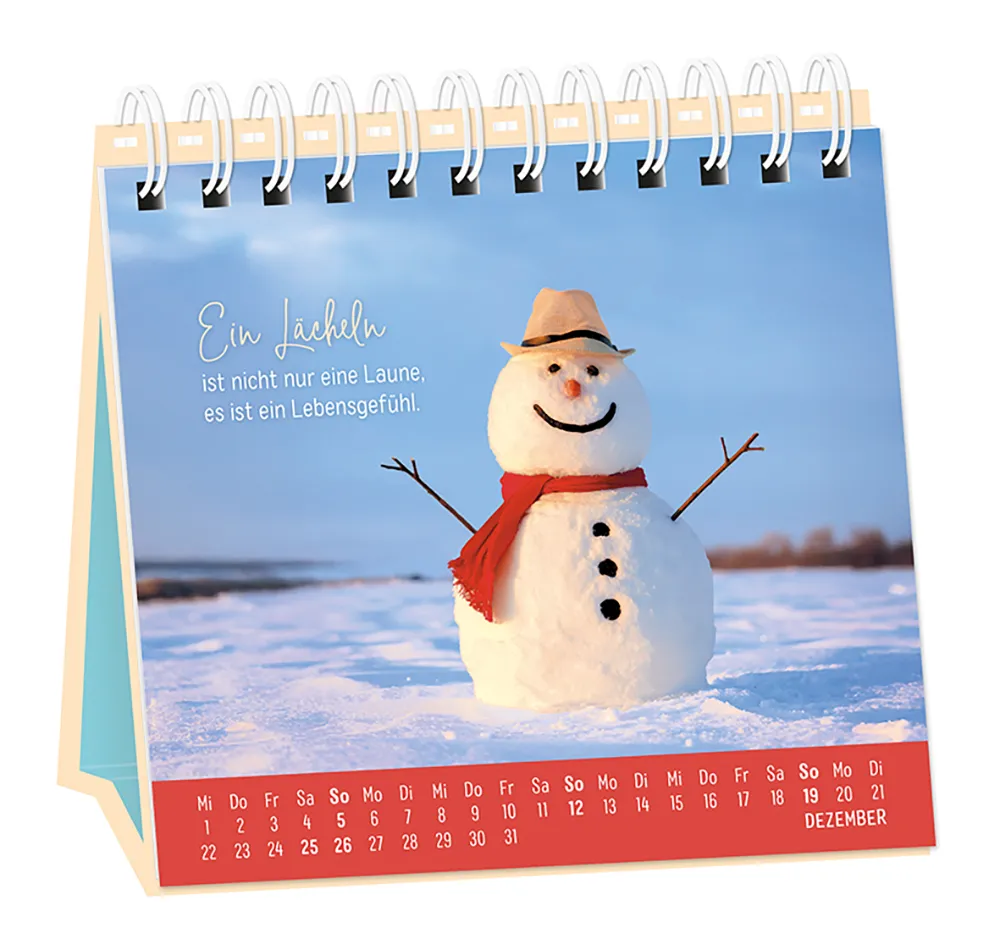 Tischkalender - "Extraportion Glück" - 2027 - Monat Dezember -  Spruch: "Ein Lächeln ist nicht nur eine Laune, es ist ein Lebensgefühl." Design: Ein lächelnder Schneemann mit Schal und Hut in einer Schneelandschaft.