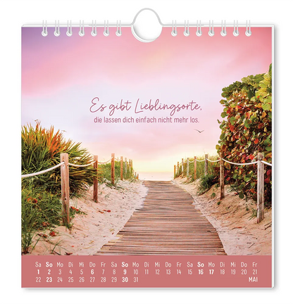 Postkartenkalender - "Strandgut" - 2027 - Monat Mai - Ein Weg aus Holzplanken zum Stand mit Pflanzen auf beiden Seiten und Rosa Wolken mit dem Spruch "Es gibt Lieblingsorte, die lassen dich einfach nicht mehr los."