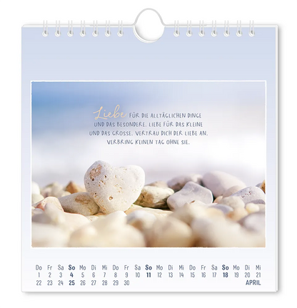 Postkartenkalender - 2027 - "Traumtage" - Monat April - Steiniger Boden mit einem Herzförmigen Stein in der Mitte mit dem Text "Liebe für die alltäglichen Dinge und das Besondere. Liebe für das Kleine und das Große. Vertrau dich der Liebe an. Verbring keinen Tag ohne sie."