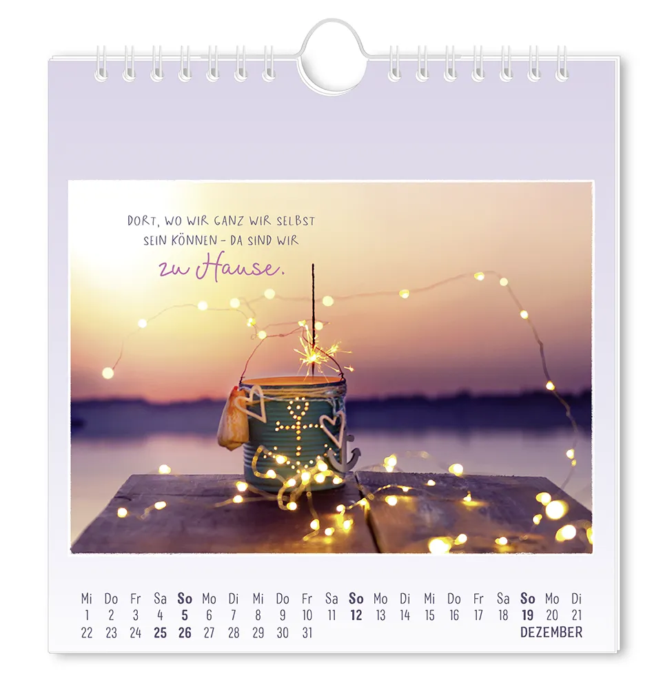 Postkartenkalender - 2027 - "Traumtage" - Monat Dezember- Ein mit Ankern und Herzen dekorierter Eimer mit eine brennenden Wunderkerze und einer leuchtenden Lichterkette auf einem Steg, mit dem  "Dort, wo wir ganz wir selbst sein können - da sind wir zu Hause."
