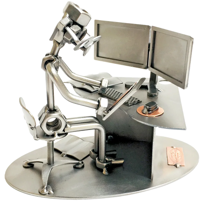 Schraubenfigur aus Metall als Grafikdesigner am Schreibtisch mit zwei Monitoren, Tastatur, Maus und Grafiktablett