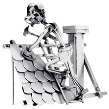 Schraubenfigur eines Dachdeckers mit Hammer auf einer Leiter an einem Ziegeldach mit Schornstein.⠋