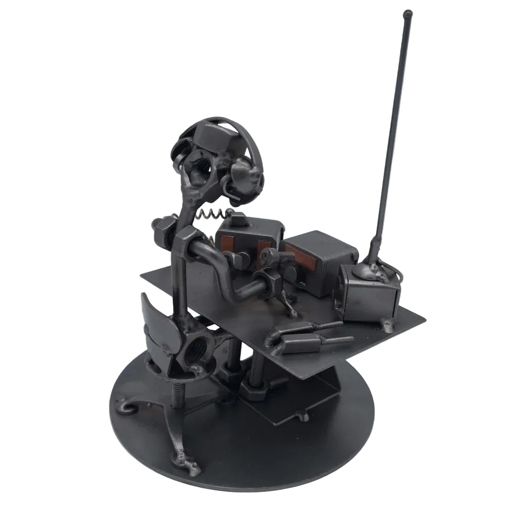 Schraubenfigur eines Funkers mit Kopfhörern am Funkgerät, schräg von hinten mit Blick auf Tisch, Stuhl und hohe Antenne