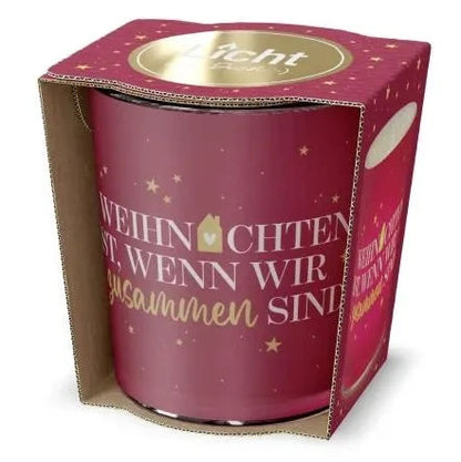 Rotes Windlicht mit goldfarbenen Sternen und Schriftzug „Weihnachten ist, wenn wir zusammen sind“ in offener roter Geschenkverpackung