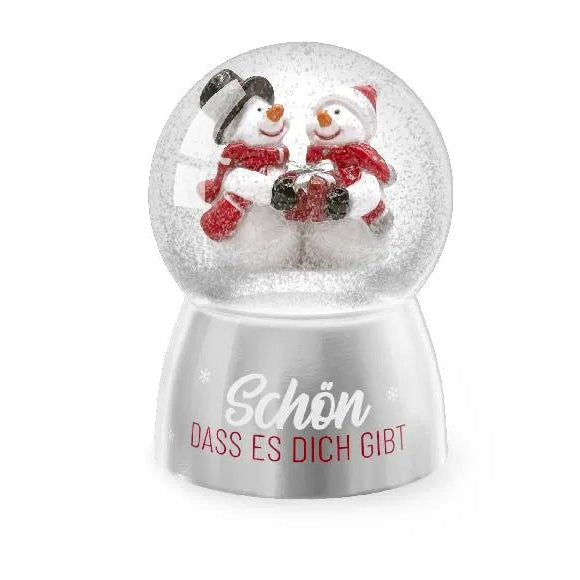 Schneekugel mit zwei Schneemännern, roten Schals und einem Geschenk auf silberfarbenem Sockel mit Schriftzug „Schön, dass es dich gibt“