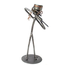 Metallmännchen als Krankenschwester mit Haube, Brille und großer Spritze auf rundem Sockel⠋