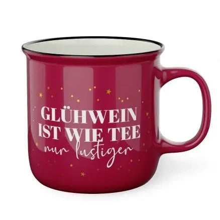 Roter Kultbecher mit schwarzem Rand, kleinen goldfarbenen Sternen und dem Schriftzug „Glühwein ist wie Tee, nur lustiger“