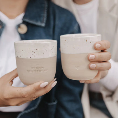 Handgefertigter Becher "Herz" aus Steingut in der Hand