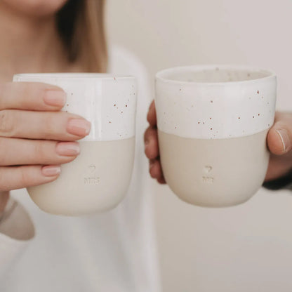 Handgefertigter Becher "Mr" aus Steingut in den Händen