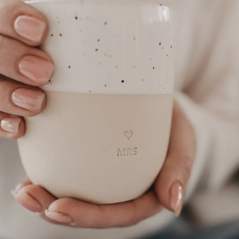 Handgefertigter Becher "Mrs" aus Steingut in den Händen
