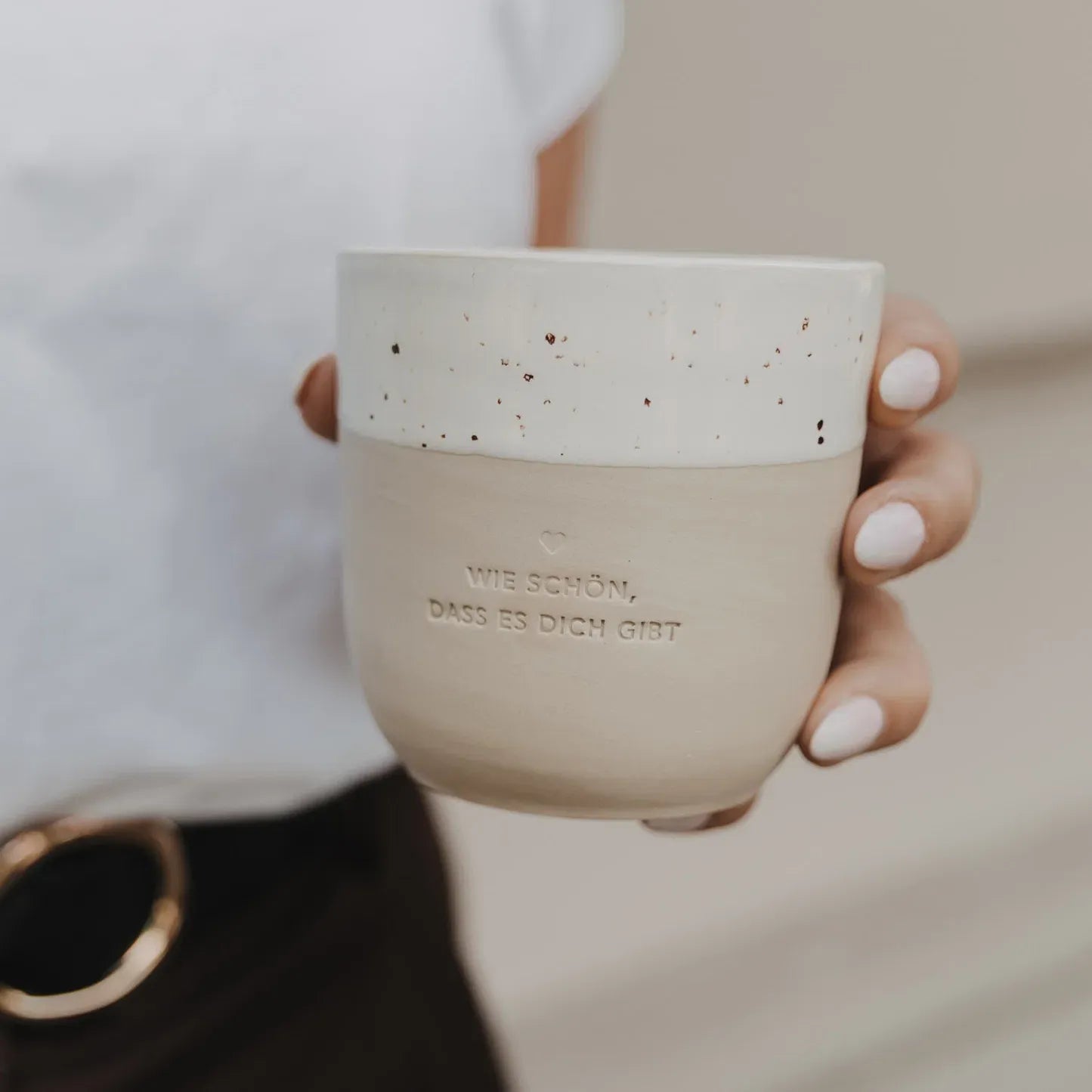 Handgefertigter Becher "Wie schön" aus Steingut in der Hand