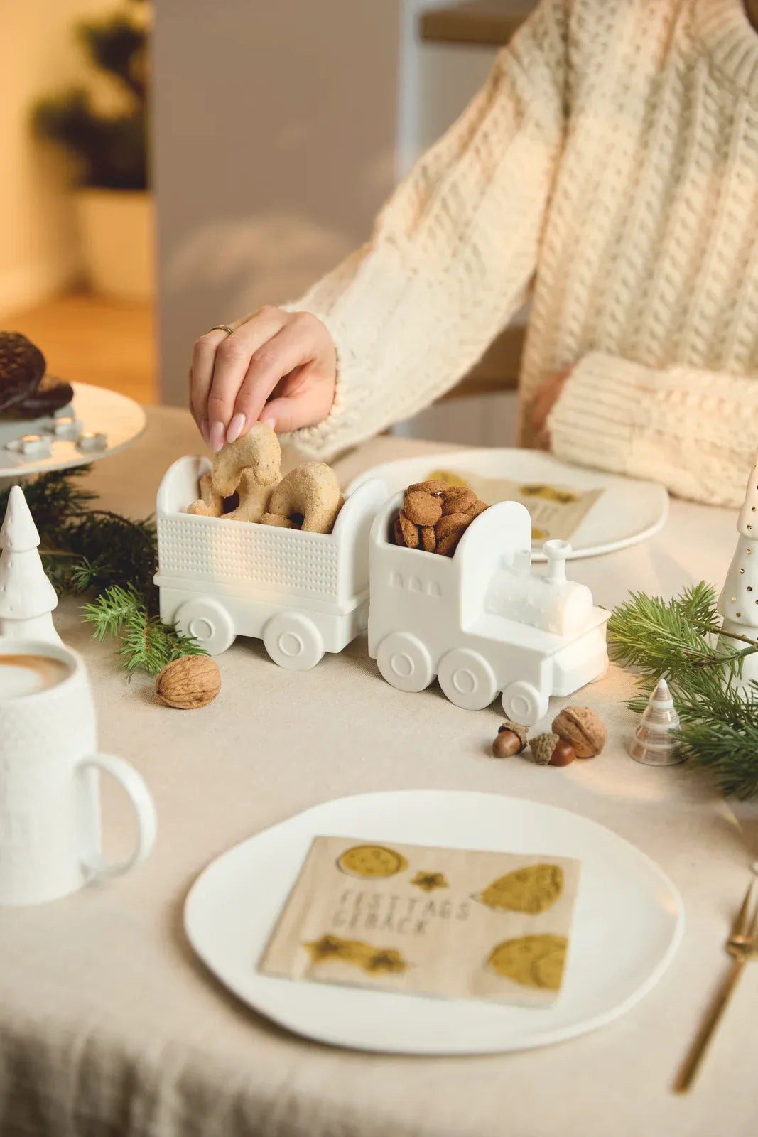 Räder Weihnachtszug-Schalen-Set aus weißem Porzellan mit Plätzchen auf einer weihnachtlich gedeckten Tafel